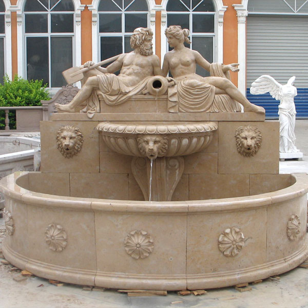 Lion head wall fountain with nude man and woman statues outdoor