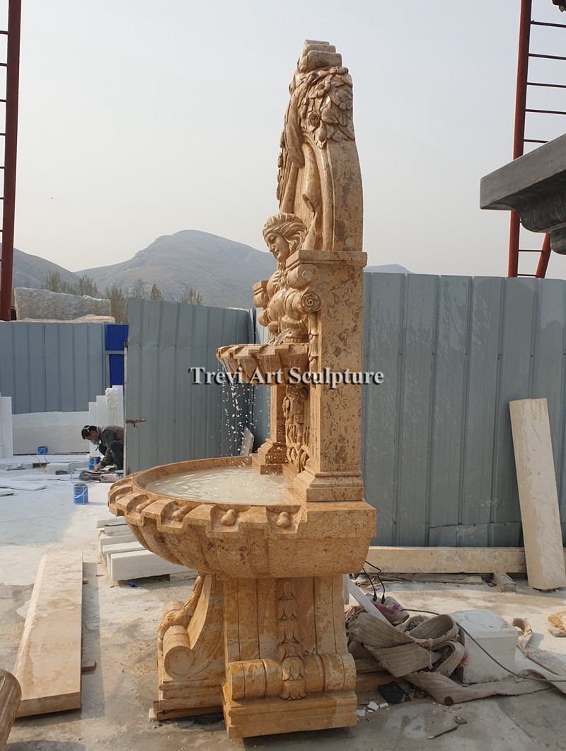 tall marble courtyard wall fountain with female relief