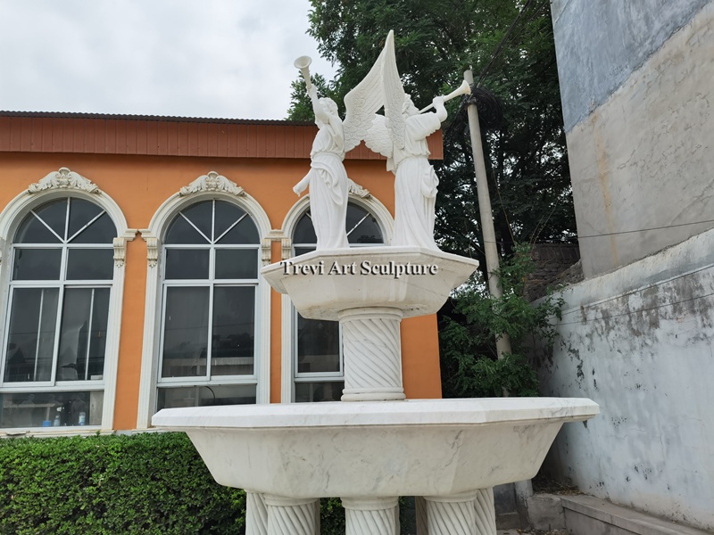 outdoor tiered water fountain with angel statue