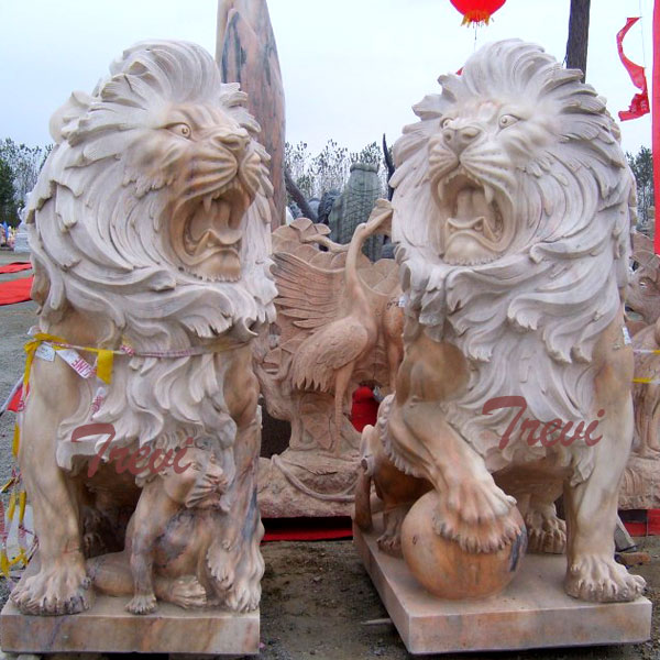 Pair of guardian lions statue with ball in front of house