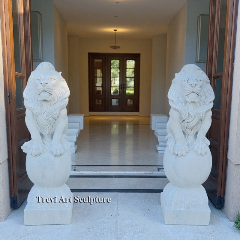 pair of lions statue sitting on the ball
