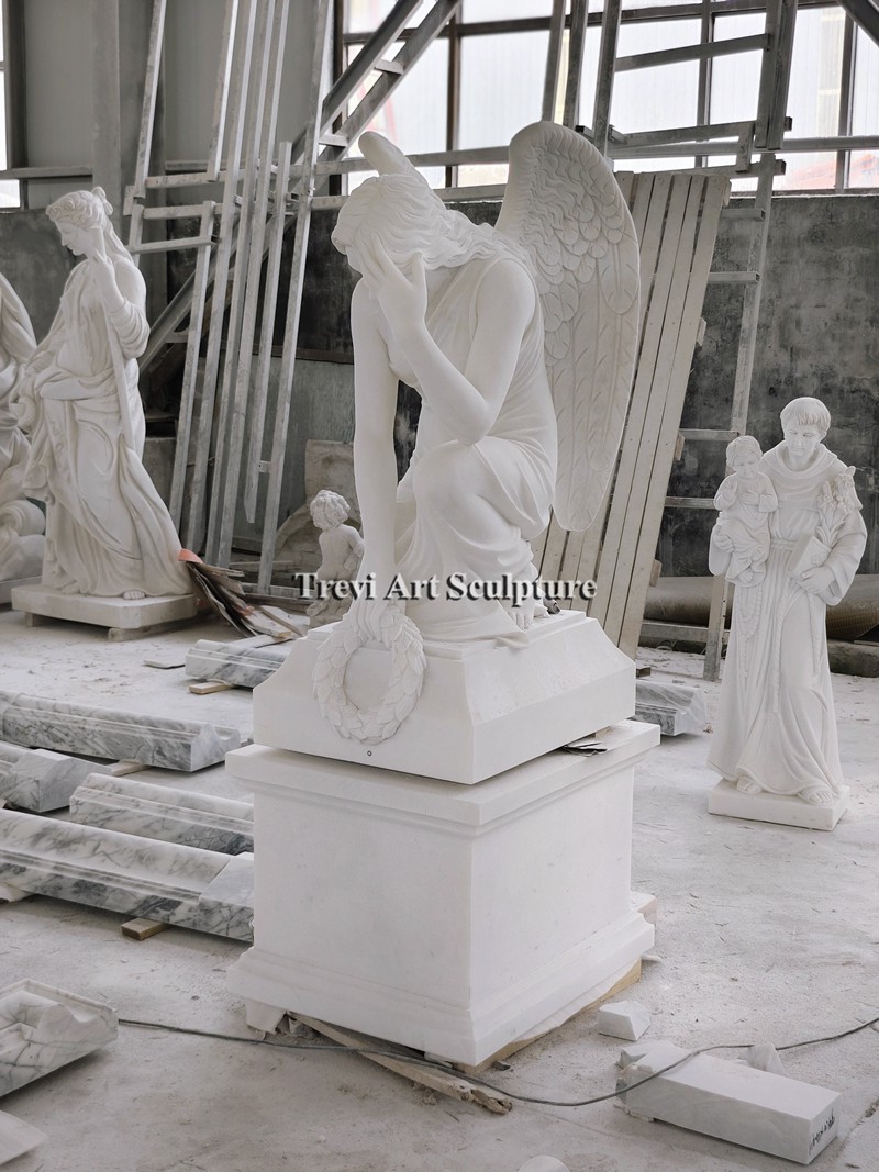 carved white marble sad kneeling angel statue