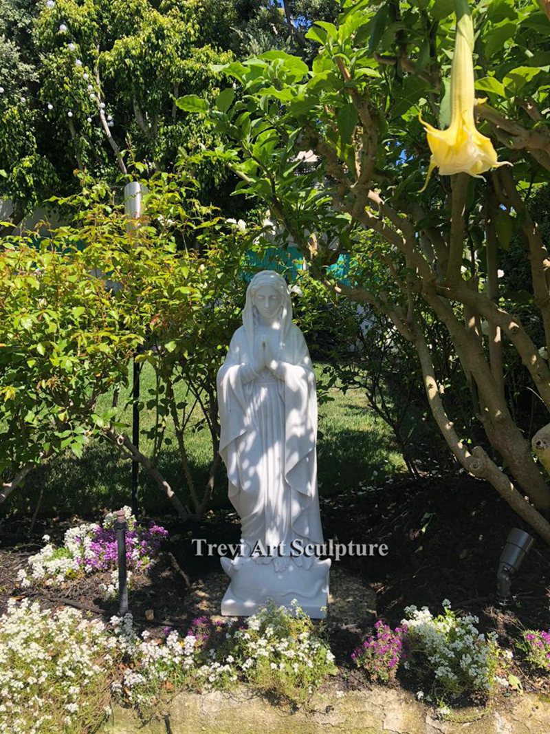 place the virgin statue among flowers