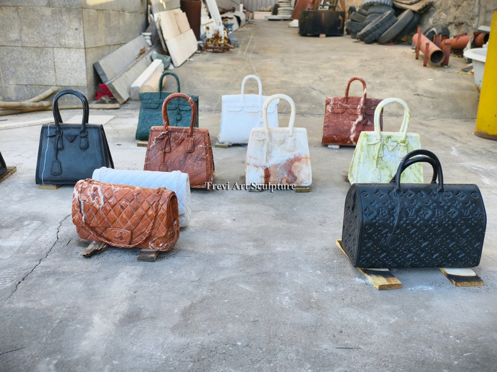 factory yard display of various colorful marble handbag sculptures