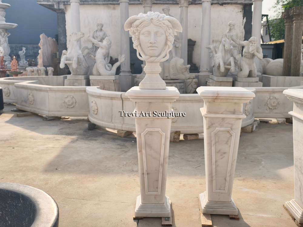 classical white marble medusa bust mounted on a matching sculpted marble pedestal