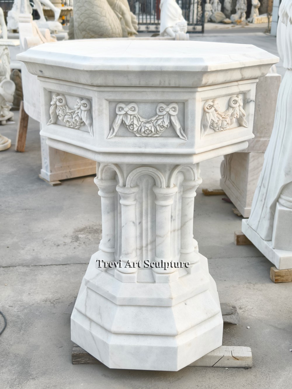 octagonal white marble church font with garland relief