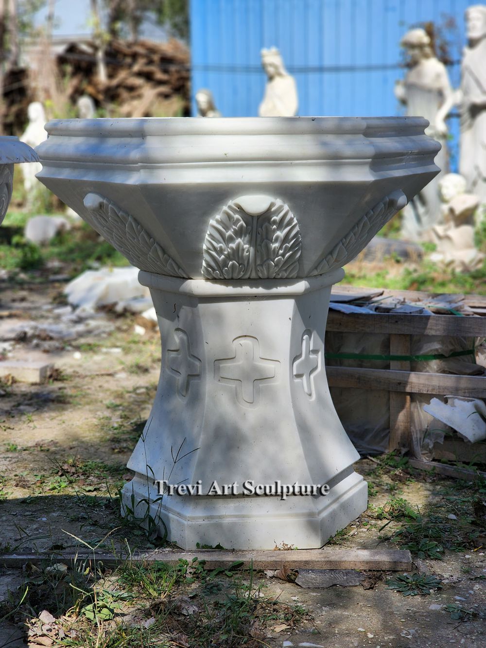 white marble church font with cross carved pedestal
